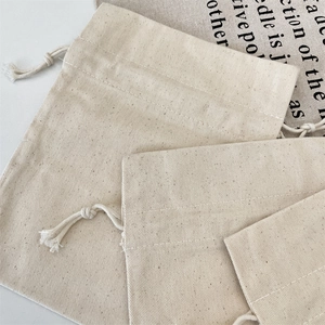Detailed view of beige canvas drawstring bags showing natural woven fabric texture and cords
