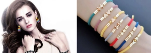 Detailed view of layered colorful braided bracelets with gold evil eye and star charms