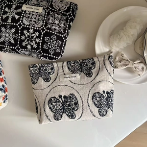 Detail of embroidered cotton linen pouches with butterfly patterns and metal zippers