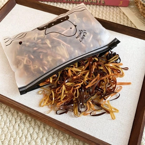 Macro shot of durable elastic hair bands in earthy tones spilled from a cartoon zipper bag