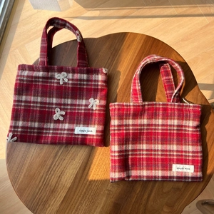 Détail de mini sacs en laine à carreaux rouge et blanc avec un nœud en crochet