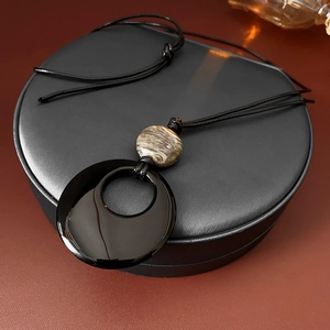Dettaglio della collana con ciondolo geometrico nero e perla in finta agata