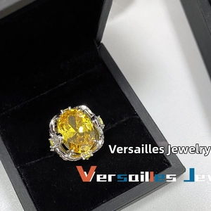 Macro shot of large oval yellow gemstone ring with intricate 18k gold hollow setting in box