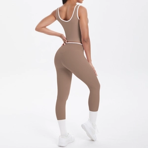 Detail of high-waisted yoga pants and tank top with white contrast piping on brown fabric