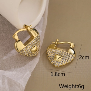 Detailed view of 18K gold plated heart earrings with sparkling cubic zirconia on white porcelain