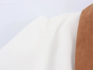 Detail shot of the shoulder seam on a corduroy dress with white and brown contrast fabric