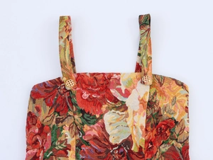 Close-up of vintage floral tapestry dress with intricate embroidery and gold buttons