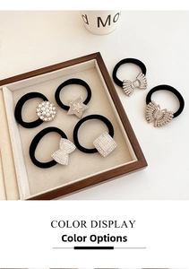 Close-up of hair ties with rhinestone charms and pearls on a velvet tray