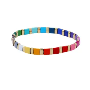 Detail of colorful bohemian stretch bracelet with square glazed beads and gold spacers