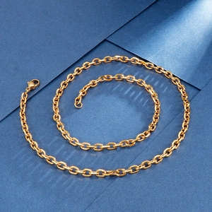Detail of gold O-chain necklace with lobster clasp on a blue textured background