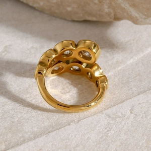 Macro shot of 18k gold plated stainless steel ring with zircon on sandstone