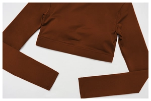 Gros plan d'un haut de yoga court rouge rouille à manches longues et coutures plates