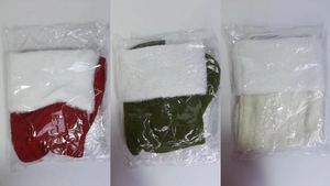 Three knit Christmas stockings in red, green and white with plush cuffs in clear packaging