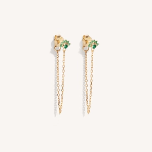 Close-up of gold dangle earrings featuring green stones and delicate tassel chains