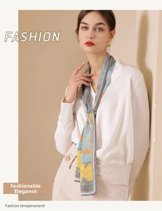 Close-up of narrow printed silk scarf with blue and orange abstract pattern on model