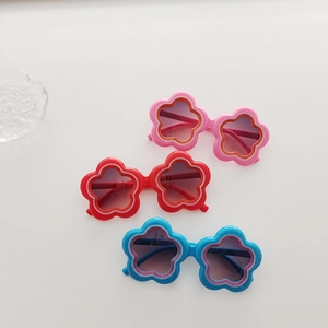 Set of three colorful flower-shaped sunglasses for girls in pink, red, and blue tones