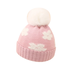 Pink baby knit hat with white cloud patterns and a fluffy pom-pom for winter warmth