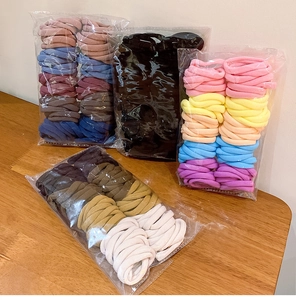Macro detail of high elasticity multi-color fabric hair ties in clear plastic packaging