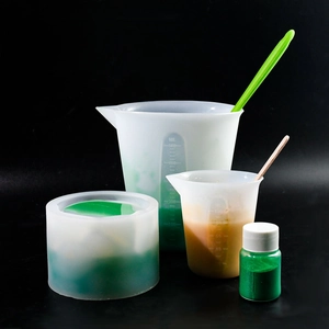 Close-up of 500ml silicone measuring cups with resin DIY tools and green pigments