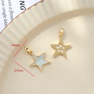 Detail of star-shaped 14x21mm gold plated pendants with white shell inlay for DIY jewelry