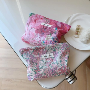 Liberty floral fabric makeup bags in pink and purple with minimalist woven label
