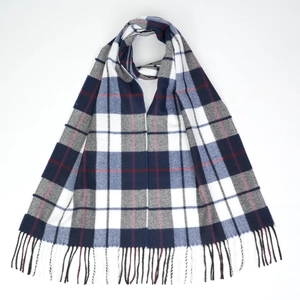 Macro detail of classic navy blue and grey plaid scarf with soft fringe trim texture