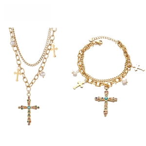 Detailed view of gold cross pendant with colorful rhinestones and evil eye bead