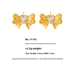 Detailed view of gold bow earrings with heart-shaped glass stone and product dimensions