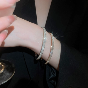 Close-up of elegant gold and silver bracelets with sparkling micro-pave diamonds on a wrist