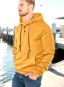 Detail of yellow knitted texture hoodie with button neckline and drawstring hood