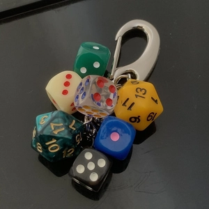 Detailed macro view of colorful polyhedral lucky dice keychain on a dark background