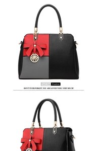Close-up of tricolor leather handbag showing red bow detail and gold charm pendant