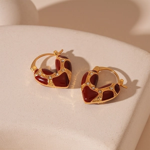 Dettaglio degli orecchini a cuore placcati oro con smalto bordeaux e strass