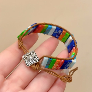 Détail de perles en pierre colorées et bracelet en cuir tressé avec boucle vintage