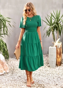 Detail of green shirred bodice and layered maxi skirt on casual summer vacation dress