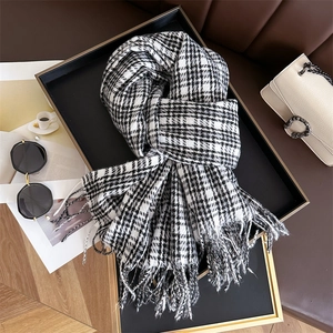 Close-up of black and white plaid cashmere-like scarf with fringe details and houndstooth pattern