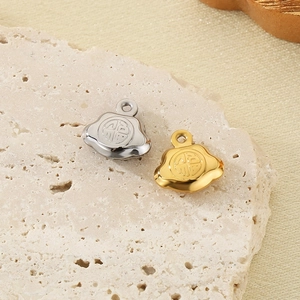 304 stainless steel hollow ruyi lock charms in silver and gold finish on stone background