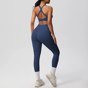 Detail of high-waist yoga leggings and cross-back sports bra set in deep blue