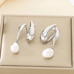 Gros plan de boucles d'oreilles en acier argenté avec perles baroques sur présentoir