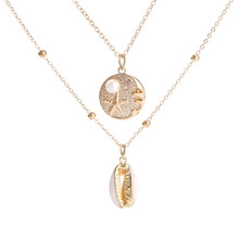 Detail van gouden dubbele ketting met schelp- en sterrenbeelden hanger voor dames.