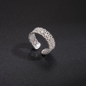 Macro shot of silver adjustable hollow flower ring with pavé zircon stones on black background