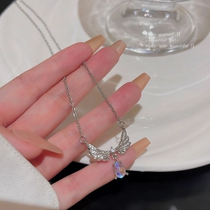 Detail showing an angel wing pendant necklace with zircons and drop-shaped opal stone