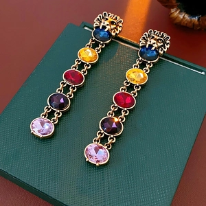 Détail de boucles d'oreilles tête de lion vintage avec pierres de couleur sur boîte