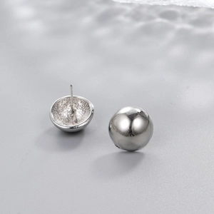 Detailed view of polished silver drop earrings showing sleek metallic finish and texture