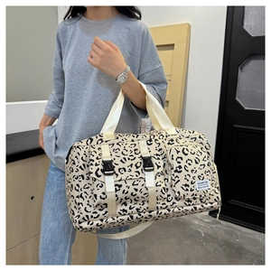 Detail of leopard print travel bag featuring front buckle pockets and durable handles