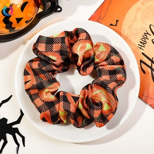 Halloween scrunchie with orange plaid pumpkin patterns on a white decorative plate