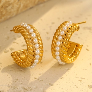 Detail view of gold C-shaped twisted hoop earrings with elegant white pearl inlay