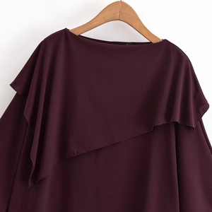 Detail of burgundy layered crewneck top showing textured fabric and asymmetrical ruffles