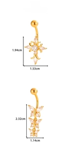 Detail view of gold belly rings with cross and butterfly charms and zircon inlay