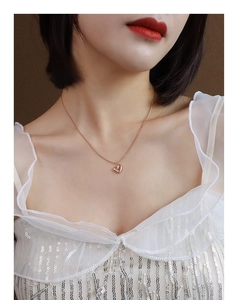 Elegant 18k rose gold heart pendant necklace on model with white sequin ruffles